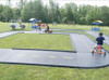 Infinity Playgrounds Formula One Road Course Trike Track, outdoor miniature racing track for kids with go-karts and themed play stations.