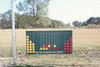 Infinity Playgrounds Connect 4 Playground Game, outdoor connect 4 game with yellow and red discs on a green playing board within a fenced area.