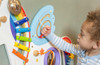SPARK & WOW Unicorn Activity Wall Panel Toy, young child playing with colorful educational wall activity panel featuring rainbow, gears, and maze elements. SPARK & WOW Unicorn Activity Wall Panel Toy, young child playing with colorful educational wall activity panel featuring rainbow, gears, and maze elements.