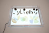 TickiT Ultra Bright LED Light Panel, illuminated display showcasing leaves, feathers, pine cones, and other natural objects for educational or display use.