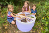 TickiT Sensory Mood Discovery Light Table, children exploring natural objects outdoors in a garden environment.