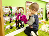 SPARK & WOW Acrylic Bubble Mirror - 9 Large Bubbles, child playing with purple plush toys in front of the reflective bubble mirror display.