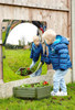 SPARK & WOW Acrylic Bubble Mirror -1 Giant Bubble, young boy looking at his reflection in a large, round, acrylic bubble mirror mounted on a wooden fence outside.