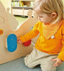 HABA Pro Toddler Sensory Activity Discovery Snail, a young child engaging with a sensory play activity involving colorful wooden parts and a snail-shaped wooden structure.