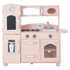 Teamson Kids Little Chef Westchester Retro Pink Play Kitchen, a children's play kitchen set designed to resemble a real kitchen with a sink, stove, oven, microwave, and refrigerator, all in light pink with silver accents.