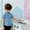 Teamson Kids Little Chef Fairfield Ivory Retro Play Kitchen, a young boy in a blue shirt playing with a toy kitchen set.