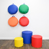 Children's Factory Soft Ottoman Trio - Rainbow, colorful round ottomans in blue, green, orange, and red, with additional yellow, blue, and red ottomans at the bottom, wall-mounted with rainbow colors.