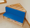 Jonti-Craft Corner Literacy Nook, wooden reading nook with blue upholstered seat and multiple storage compartments for books and educational toys.