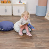 Children's Factory Mini Round Pouf with Handle - Gray and Navy, young girl sitting on the pouf reading a book in a children's playroom.