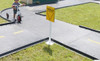 Infinity Playgrounds Trike Path Single Intersection Piece, a black plastic playground trike path with a yellow yield sign in the center.