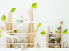 HABA Pro Grow.upp Wall Play Shelves, a children's wall-mounted storage unit designed like a whimsical tree with green leaf accents, showcasing toys, books, and a slide for playful organization.