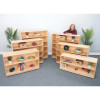 Whitney Brothers Mobile Bookshelf Cabinet 54H, multiple light wood bookshelves filled with toys, books, and decorative items, with a woman smiling behind one of the shelves in a classroom or playroom setting.