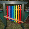 Playmore Designs 8 Note Rainbow Chime Unit With Drums, a colorful outdoor musical instrument featuring rainbow-colored chimes and drums, perfect for children's play and musical education.