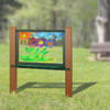 Playmore Designs Recycled Plastic Art Easel, colorful children's outdoor painted artwork on transparent surface showing a sun, flowers, and clouds.