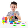 Guidecraft Interlox Square Discs Construction Set - 96 Piece Set, a young boy assembling colorful square plastic discs to create various structures.