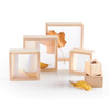 Guidecraft Magnification Wooden Blocks, set of wooden blocks with clear and mirrored surfaces, accompanied by autumn leaves for sensory and visual exploration.