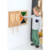 Moje Bambino Frame For Fine Motor Skills Wall Panels, a young boy interacting with a wooden sensory wall panel for developing fine motor skills.