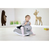 Moje Bambino Soft Foam Rocking Seats, a child happily sitting on a soft, gray foam rocking seat designed like a cute animal with a smiling face, in a playful indoor setting with animal wall décor.