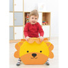 Moje Bambino Animal Friends Soft Seating, a children's animal-themed soft seat shaped like a lion with a smiling face, being used by a young girl in a red shirt in a playroom.