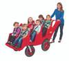 Angeles BYE BYE BUGGY 6 Passenger Stroller Never Flat Fat Tire, Red/Gray, a red pedal-powered cart with six young children seated, accompanied by a woman pushing the stroller, designed for outdoor family outings and group transportation for kids.