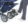 Angeles SureStop BYE-BYE Folding Commercial Stroller 4 Passenger, image showing a person operating a blue multi-passenger stroller with large wheels and a white sole shoe, designed for transporting four children.