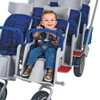 Angeles RUNABOUT 6 Passenger Stroller, a young boy seated securely with a safety harness in a multi-seat stroller designed for six children, featuring blue and gray colors, sturdy wheels, and a spacious design for comfortable travel.
