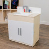 Angeles White Play Sink - Assembled, child play sink with a white basin, gray and red faucet, and cabinet with white doors and gray handles in a playroom setting.