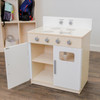 Angeles White Play Stove - Assembled, wooden play kitchen stove with four burner stove top, control knobs, and storage cabinet with door, in a playroom setting.