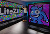 LiteZilla Giant Lite Brite - 8' x 5' , large interactive LED art installation with a woman creating colorful light patterns.
