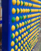 LiteZilla Spinfinity Ball STEM Wall Activity, colorful yellow and green plastic balls mounted on a blue wall for engaging children's educational play.