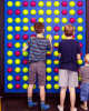 LiteZilla Spinfinity Ball STEM Wall Activity, children playing with a colorful wall-mounted ball activity with yellow and pink balls.