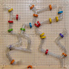 LiteZilla Kidworx Twist and Turn Tubes Wall Ball Run Bundle, colorful plastic tubes with interlocking joints arranged to form a creative ball run on a pegboard wall. LiteZilla Kidworx Twist and Turn Tubes Wall Ball Run Bundle, colorful plastic tubes with interlocking joints arranged to form a creative ball run on a pegboard wall.