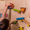 LiteZilla Kidworx Turbo Trax Raceway Wall Ball Run, children playing with a wall-mounted marble run toy system for racing balls.