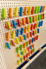LiteZilla KidWorx™ Instant Reset Domino Dash Wall Activity, colorful wooden domino pieces arranged on a pegboard wall for children's educational and recreational activity.