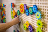 LiteZilla Kidworx™ Gizmo Gears STEM Wall Activity, colorful gear wall puzzle with multiple interlocking gears on a pegboard.