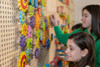 LiteZilla Kidworx™ Gizmo Gears STEM Wall Activity, colorful wooden gears mounted on a pegboard wall, children engaging in STEM learning and mechanical assembly.