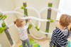 HABA Pro Wall Marble Run Set - Velcro Ball Track, children playing with a marble run maze on a wall with colorful pipes and Velcro balls