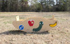 Infinity Playgrounds Slayden's Toddler SeeSaw, beige see-saw with colorful fruit and insect illustrations on a grass field