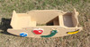 Infinity Playgrounds Slayden’s Toddler Caterpillar Seesaw, beige plastic toddler see-saw with colorful insect and fruit decorations, placed outdoors on grass.