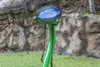 Freenotes Calypso Outdoor Tongue Drum, vibrant green musical instrument outdoors with a rock wall background.