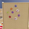 Flash Furniture Bright Beginnings Multicolor Chain and Gears Accessory Set for Modular STEAM Wall Systems - 79 Pack, colorful interconnected gear pieces and chains on a beige pegboard wall.