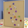 Flash Furniture Bright Beginnings Multicolor Chain and Gears Accessory Set for Modular STEAM Wall Systems - 79 Pack, colorful gears and chain links arranged on a beige pegboard wall.