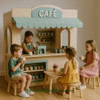 Kid's Wood Store Café Wooden Playhouse - Indoor or Outdoor, children playing with toy cups inside a wooden play store with a small table and chairs