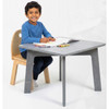 Playscapes Nordic Furniture Collection Set - Select Stain Color, a child sitting at a modern gray kids' table with a natural wood chair, engaging with an open book and colored markers.