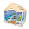 Whitney Brothers Nature View™ Play Beach House, children’s wooden beach-themed playhouse with tropical ocean scene walls, a small round rug, and a miniature umbrella and lounge chair inside.