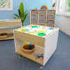 Whitney Brothers elevatED™ Adjustable Light Table, children’s art and activity table with illuminated surface, on a classroom floor with educational materials and storage bins in the background.