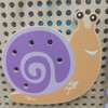 LiteZilla Kidworx™ Animal Assembly Adventure Wall Activity, colorful snail-shaped wooden wall game with holes for placing animal-shaped pieces.
