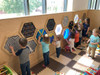 LiteZilla Multi-Sensory Hexagon Panel - Mini Lite Brite Classic, children playing with interactive light-up hexagon panels in a playroom.