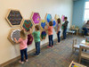 LiteZilla Multi-Sensory Hexagon Panel - Hex-A-Glow XL, children interacting with colorful sensory panels on a wall in a learning center.