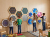 LiteZilla Multi-Sensory Hexagon Panel - Fidget Spinner XL, large colorful educational sensory panels with boys and girls interacting and playing on a wooden wall.